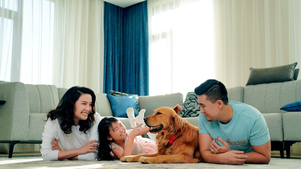 A happy family bonding at home with their golden retriever in a cozy living room setting.